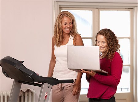 simsearch:614-05955639,k - Young woman showing laptop to mother on treadmill Photographie de stock - Premium Libres de Droits, Code: 614-08873603