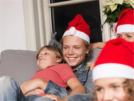 simsearch:693-06435898,k - Family wearing Santa hats on sofa Stock Photo - Premium Royalty-Free, Code: 614-08873631