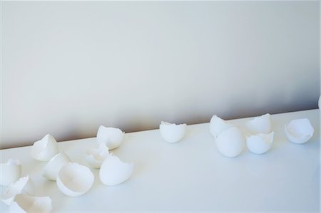 Broken eggshells on white table Stock Photo - Premium Royalty-Free, Code: 614-08873651