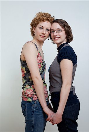 sensual gay - Portrait of lesbian couple holding hands, studio shot Stock Photo - Premium Royalty-Free, Code: 614-08873691