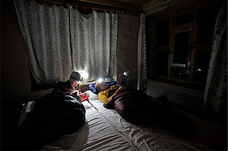 flashlight book - Couple in room in sleeping bags, Yak Kharka, Nepal Stock Photo - Premium Royalty-Free, Code: 614-08873719