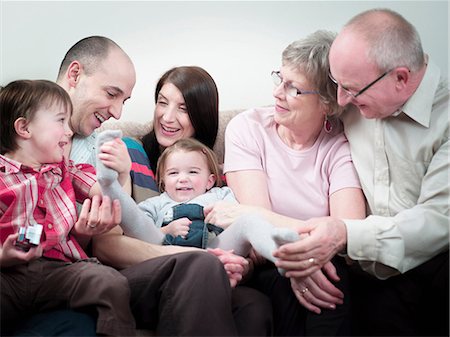 father tickle - Three generation family sitting on sofa Stock Photo - Premium Royalty-Free, Code: 614-08873763