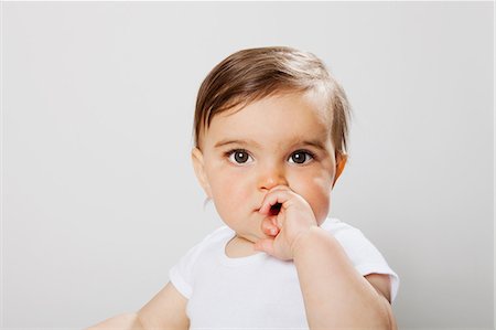 shy baby - Baby boy looking at camera, hand covering mouth Stock Photo - Premium Royalty-Free, Code: 614-08873888