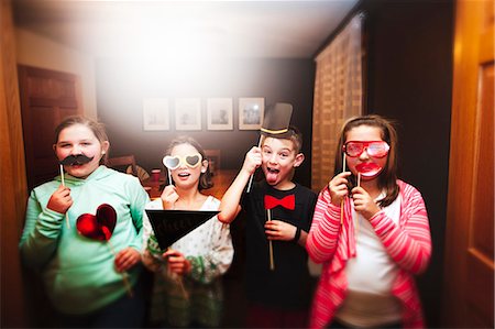 simsearch:6113-07148073,k - Portrait of boy and three girls holding sunglasses and mustache stick masks at party Stock Photo - Premium Royalty-Free, Code: 614-08884768