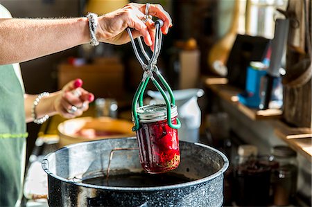 Woman's hands inserting beetroot preserves jar into saucepan Stock Photo - Premium Royalty-Free, Code: 614-08884997