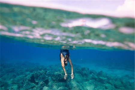 Underwater view of woman diving into water, Oahu, Hawaii, USA Stock Photo - Premium Royalty-Free, Code: 614-08880835