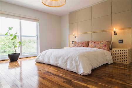 King size bed in bedroom with American walnut hardwood flooring on the upstairs floor inside a modern cube style home, Quebec, Canada Stock Photo - Premium Royalty-Free, Code: 614-08881124