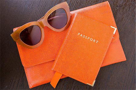 Overhead view of orange purse, passport and sunglasses Stock Photo - Premium Royalty-Free, Code: 614-08881177