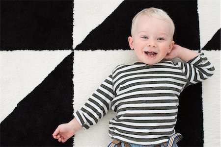 single geometric shape - Portrait of young boy lying on floor, smiling Stock Photo - Premium Royalty-Free, Code: 614-08881359