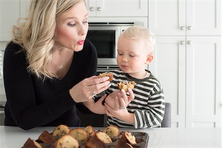 Mother and son in kitchen, breaking freshly baked cake, ready to taste Stock Photo - Premium Royalty-Free, Code: 614-08881352