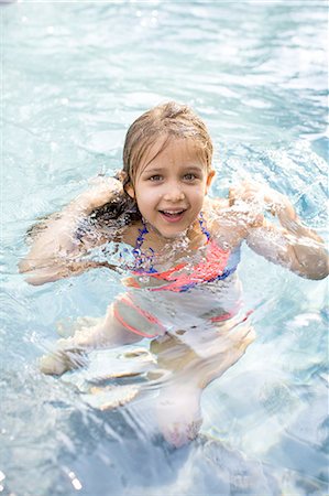 Portrait of girl treading water in outdoor swimming pool Stock Photo - Premium Royalty-Free, Code: 614-08908358