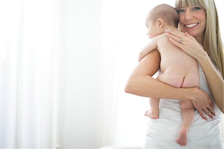 Portrait of mid adult woman carrying naked baby son Foto de stock - Sin royalties Premium, Código: 614-08926071