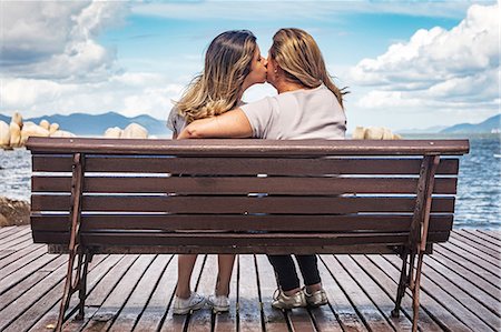 Rear view of mother and daughter on park bench kissing Photographie de stock - Premium Libres de Droits, Code: 614-08926424