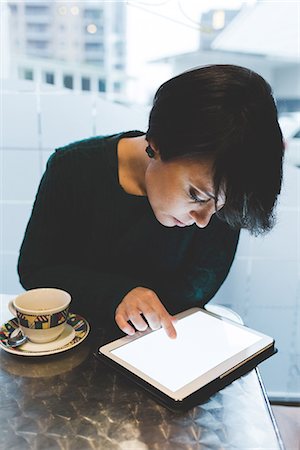 simsearch:649-07560130,k - Woman in cafe using touchscreen on digital tablet Stock Photo - Premium Royalty-Free, Code: 614-08946733