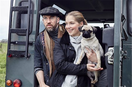 Country couple with dog looking out from back door of off road vehicle Stock Photo - Premium Royalty-Free, Code: 614-08982680