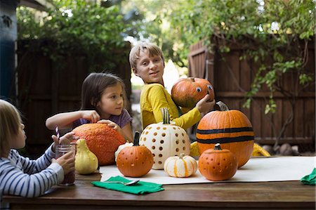 simsearch:614-06896931,k - Boy and two sisters preparing pumpkins on garden table Photographie de stock - Premium Libres de Droits, Code: 614-08983554