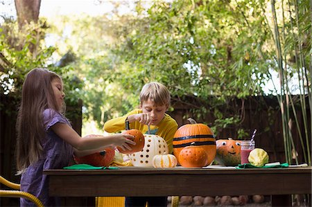 simsearch:614-08270379,k - Boy and sister carving pumpkins on garden table Stock Photo - Premium Royalty-Free, Code: 614-08983558