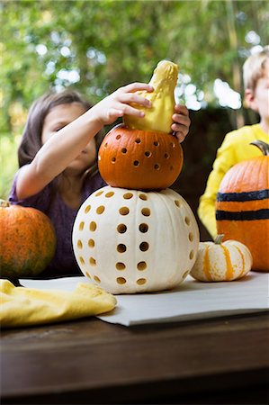 simsearch:614-08270379,k - Girl and brother stacking carved pumpkins on garden table Stock Photo - Premium Royalty-Free, Code: 614-08983559