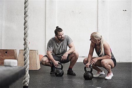 squatting man - Couple with kettlebells in cross training gym Stock Photo - Premium Royalty-Free, Code: 614-08983826