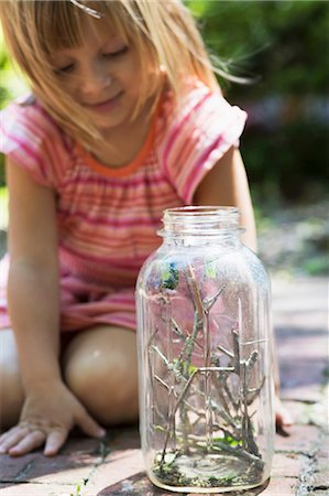 simsearch:614-06895765,k - Girl kneeling to watch caterpillar jar in garden Stock Photo - Premium Royalty-Free, Code: 614-08990594