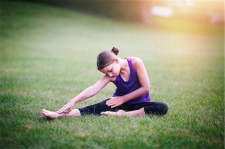 preteen girls exercising pictures - Girl stretching on grass Stock Photo - Premium Royalty-Free, Code: 614-08990703