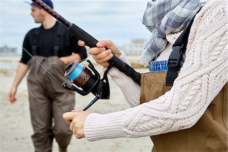 people sports in america - Cropped shot of woman in waders winding sea fishing reel on beach Photographie de stock - Premium Libres de Droits, Code: 614-08990757