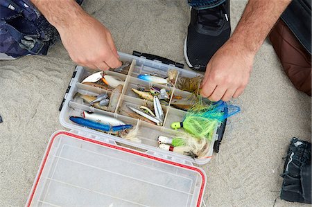 sports and fishing - Male sea fisher hands selecting fishing hook on beach Stock Photo - Premium Royalty-Free, Code: 614-08990772