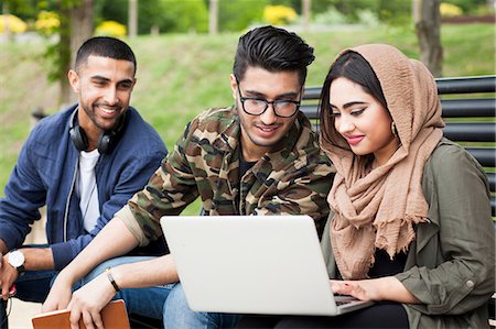 simsearch:614-07031973,k - Three friends, sitting on bench in park, looking at laptop Stock Photo - Premium Royalty-Free, Code: 614-08990864