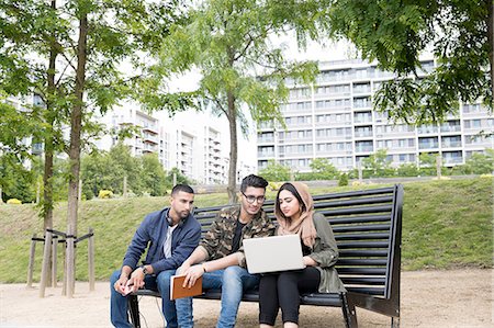 simsearch:614-07031973,k - Three friends, sitting on bench in park, looking at laptop Stock Photo - Premium Royalty-Free, Code: 614-08990879