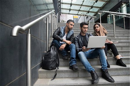 simsearch:614-07031973,k - Three friends, sitting on steps, looking at laptop Stock Photo - Premium Royalty-Free, Code: 614-08990870