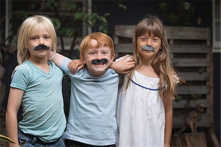 simsearch:614-03469543,k - Children wearing fake mustaches looking at camera smiling Stock Photo - Premium Royalty-Free, Code: 614-08991140