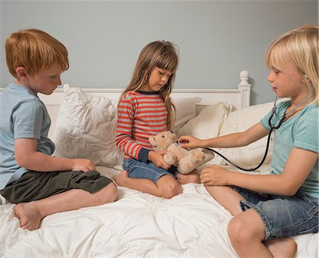 role playing - Children playing vets with stethoscope and soft toy Stock Photo - Premium Royalty-Free, Code: 614-08991159