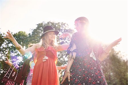 Two young boho women dancing in sunlight at festival Stock Photo - Premium Royalty-Free, Code: 614-08991254