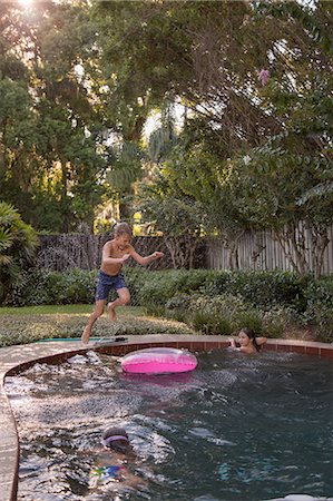 simsearch:649-06812049,k - Children swimming in garden pool, young boy jumping in, mid-air Stock Photo - Premium Royalty-Free, Code: 614-09017191