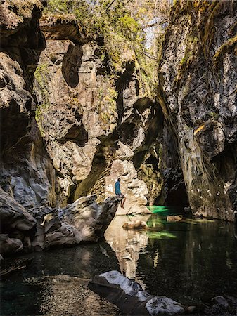 simsearch:614-07486939,k - Mid adult tourist sitting on rock looking at river Azul gorge, Cajon del Azul near El Bolson, Patagonia, Argentina Stock Photo - Premium Royalty-Free, Code: 614-09017685