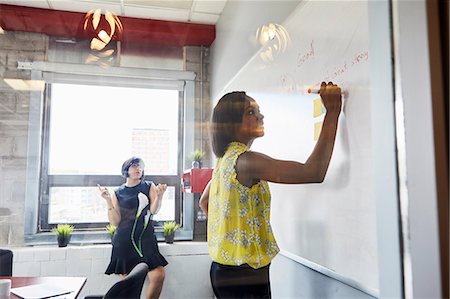 simsearch:614-06718107,k - Two women in office, solving problem, using whiteboard, sticky notes stuck on whiteboard Stock Photo - Premium Royalty-Free, Code: 614-09017724