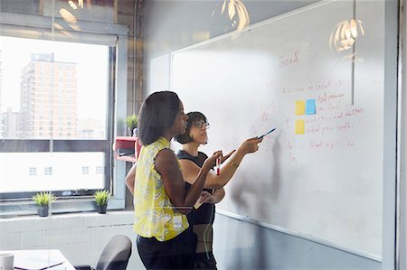 simsearch:614-06718107,k - Two women in office, solving problem, using whiteboard, sticky notes stuck on whiteboard Stock Photo - Premium Royalty-Free, Code: 614-09017728