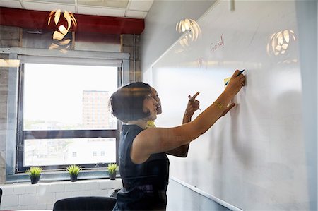 simsearch:614-06718107,k - Two women in office, brainstorming, sticking sticky notes on whiteboard Stock Photo - Premium Royalty-Free, Code: 614-09017722
