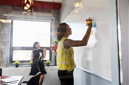 simsearch:614-06718107,k - Two women in office, solving problem, using whiteboard, sticky notes stuck on whiteboard Stock Photo - Premium Royalty-Free, Code: 614-09017723