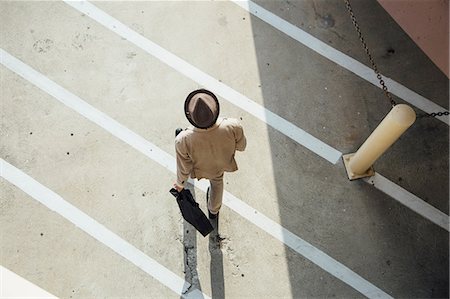 pantsuit - Young man walking across road, overhead view Stock Photo - Premium Royalty-Free, Code: 614-09018011