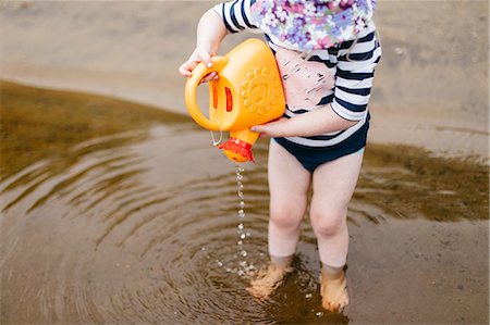 simsearch:614-07031875,k - Girl standing ankle deep in lake pouring water from toy watering can, Huntsville, Canada Foto de stock - Sin royalties Premium, Código: 614-09026435