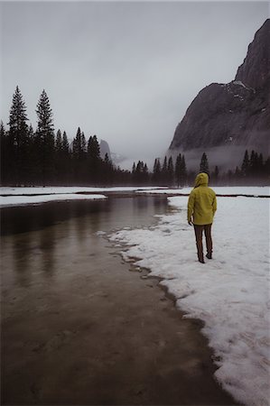 simsearch:649-08924209,k - Rear view of male hiker looking out over snow covered landscape and river, Yosemite Village, California, USA Stock Photo - Premium Royalty-Free, Code: 614-09026462