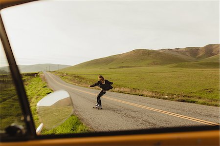 Car window view of young male skateboarder skateboarding along rural road, Exeter, California, USA Stock Photo - Premium Royalty-Free, Code: 614-09026471