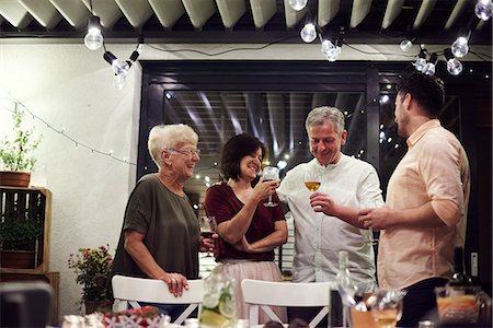 Group of people standing beside dinner table, holding wine glasses Stock Photo - Premium Royalty-Free, Code: 614-09026655