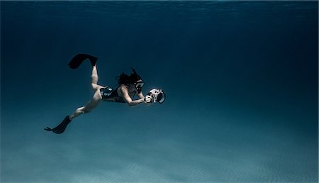 Underwater view of female free diver with underwater camera, Bimini, Bahamas Stock Photo - Premium Royalty-Free, Code: 614-09027062