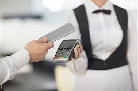 simsearch:6108-06907863,k - Waitress holding payment machine toward customer, customer paying by contactless method Stock Photo - Premium Royalty-Free, Code: 614-09027154