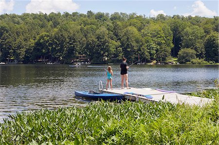 dock with lake - Two young girls standing on jetty, fishing using fishing rods Stock Photo - Premium Royalty-Free, Code: 614-09038788