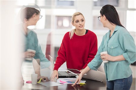 Two young female office workers meeting at office desk Stock Photo - Premium Royalty-Free, Code: 614-09038823