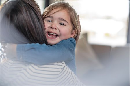 Girl hugging her mother in living room Stock Photo - Premium Royalty-Free, Code: 614-09038934