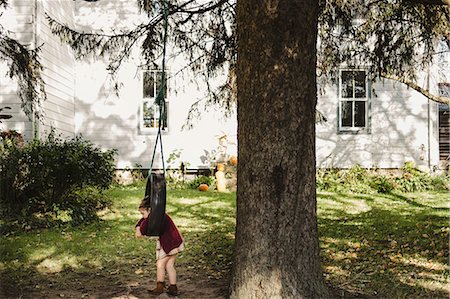 Girl on tyre swing hanging from tree Stock Photo - Premium Royalty-Free, Code: 614-09039019